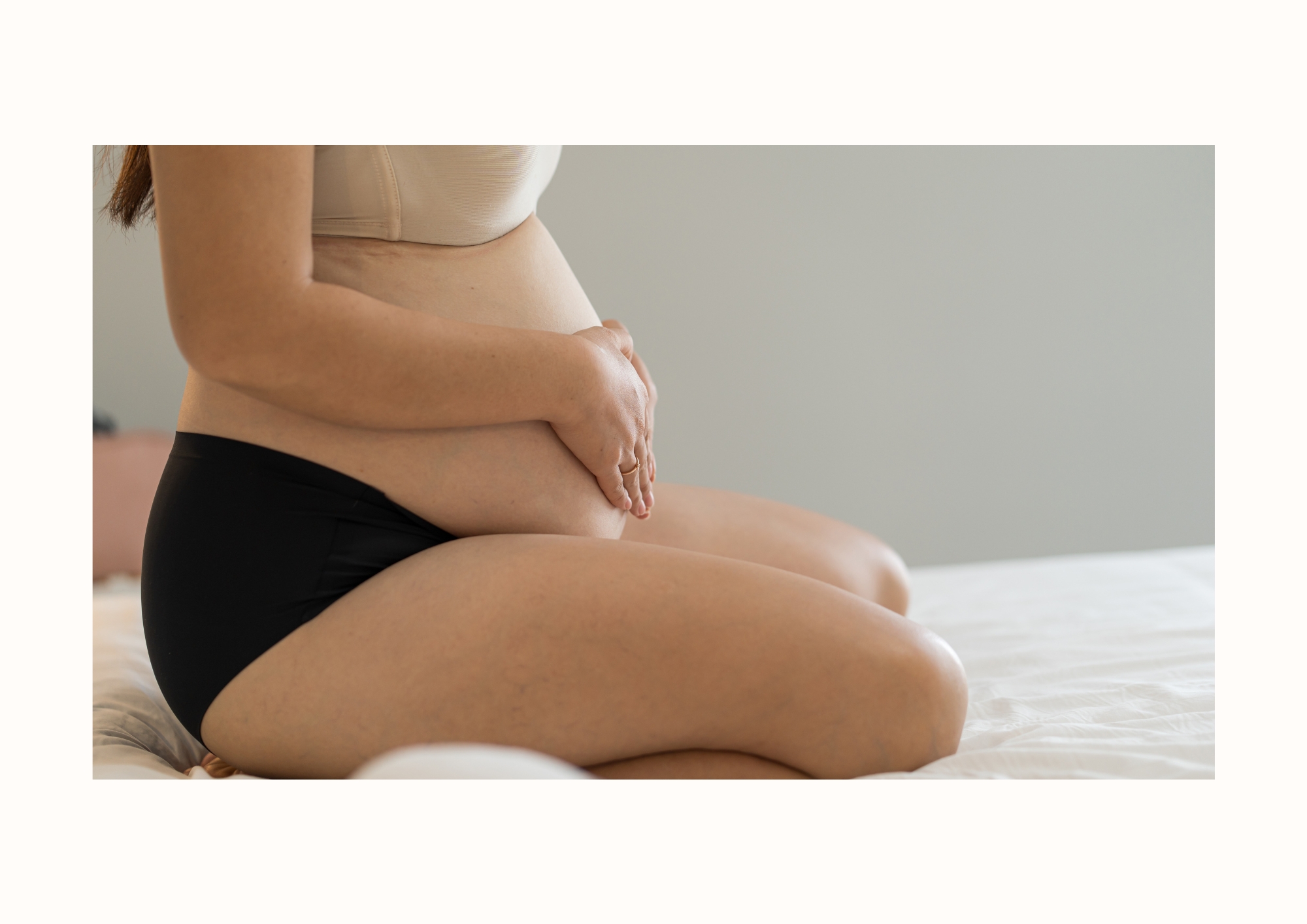 Gravid person håller händerna om magen